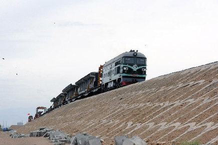 A train transports rail laying materials for the construction of Hami-Lop Nur railway line in northwest China's Xinjiang Uygur Autonomous Region, June 19, 2012. [Xinhua]