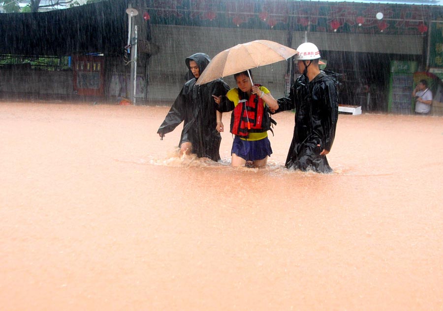 Firemen help a trapped woman to safety as heavy rainfall hits Qinzhou, a city in southern China's Guangxi Zhuang autonomous region on Wednesday.