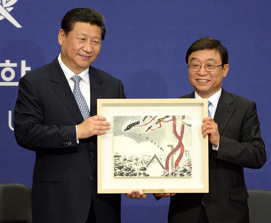 Chinese President Xi Jinping receives a present at the Global Education Center for Engineers of Seoul National University on the second day of his state visit to South Korea, July 4, 2014. [China.org.cn]