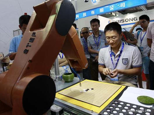 A man plays gobang against a robot during the China International Robot Show in east China's Shanghai, July 9, 2014. The three-day show kicked off on Wednesday, demonstrating latest achievements in the robot industry. [Xinhua] 