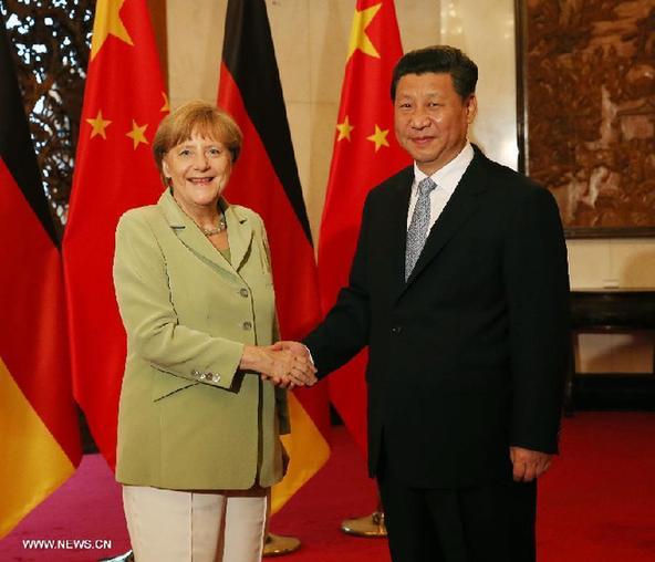 Chinese President Xi Jinping (R) shakes hands with German Chancellor Angela Merkel during their meeting in Beijing, capital of China, July 7, 2014. [Liu Weibing/Xinhua] 