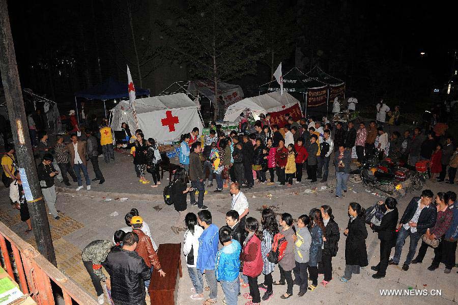 Victims queue to get relief materials from volunteers of the Red Cross Society of China in Lushan County of Ya'an City, southwest China's Sichuan Province, April 21, 2013. 