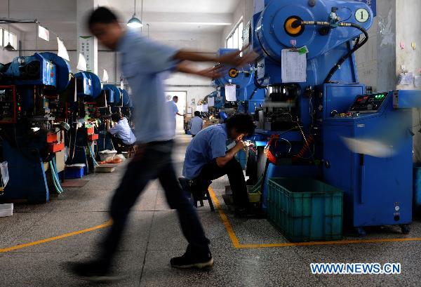 Workers are seen in a workshop of an electric switch company in Wenzhou, east China's Zhejiang Province, June 30, 2011. [Xinhua] 