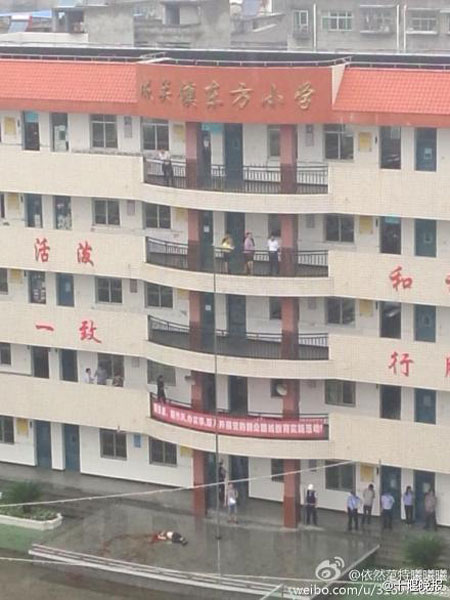 The photo published by a Weibo user on Monday, September 1, 2014, shows the body of the suspect lying in blood on a platform just outside the school building. [Photo: Weibo.com]
