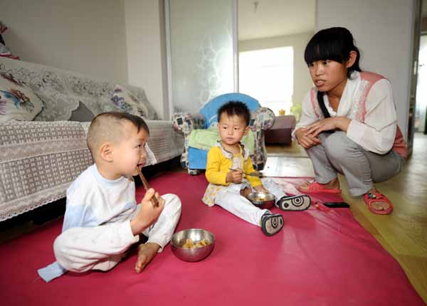 Xu Aixiang encourages her foster child, Wu Zhenfeng, to use his foot to hold chopsticks for dinner in their home in Taiyuan, Shanxi province. Wu was born without arms. Yan Yan / Xinhua 