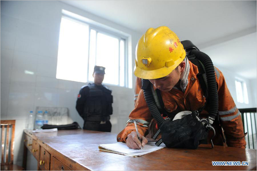 A rescuer signs before he goes down to the mine pit after a gas outburst in Qianxi County, southwest China&apos;s Guizhou Province, Oct. 7, 2014.[Photo/Xinhua]