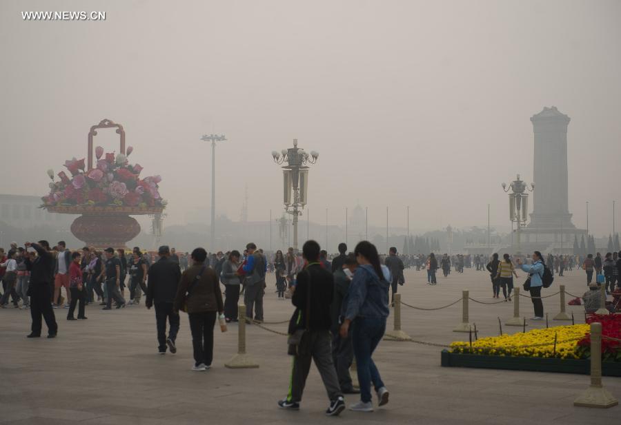 Tourists visit the smog-shrouded Tian&apos;anmen Square in Beijing, capital of China, Oct. 9, 2014.