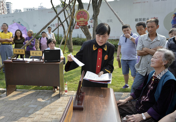 A judge from Chongqing Jiangbei District People's Court explains legal documents to a defendant as the court holds a trial by the roadside in a move to increase convenience for the public and provide education on the judicial process.