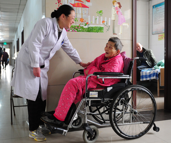 Si Dongmei (left), director of nursing at a medical care institute for elderly people who are unable to live independently because of illness or disability, in Xi'an, Shaanxi province, chats with a resident. Photos By Ding Haitao / Xinhua