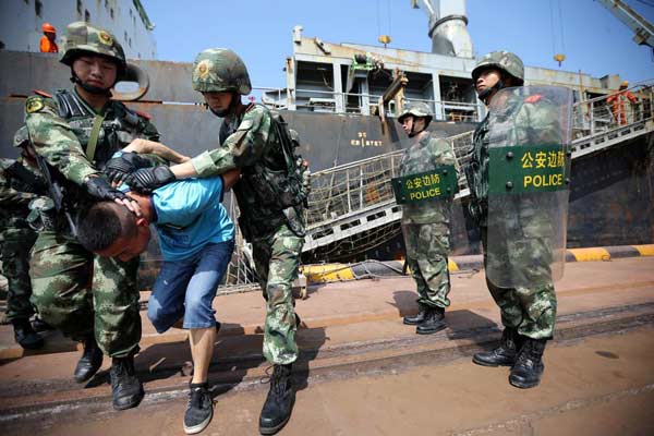 Border police arrest a smuggler during a anti-smuggling drill in Qingdao, East China's Shandong province, Sept 25, 2014. [Photo/Xinhua] 