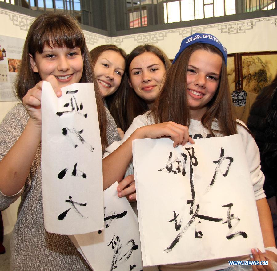 Serbian girls show their Chinese calligraphy at the 59th Belgrade Book Fair, in Belgrade, Serbia, Oct. 26, 2014. China has taken part in the book fair as host country. [Xinhua]