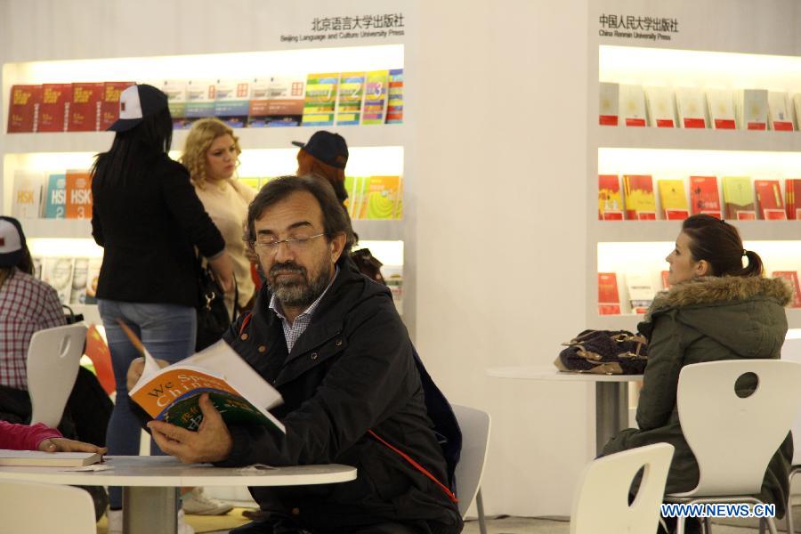 A local resident reads a Chinese book at the 59th Belgrade Book Fair, in Belgrade, Serbia, Oct. 26, 2014. China has taken part in the book fair as host country. [Xinhua]