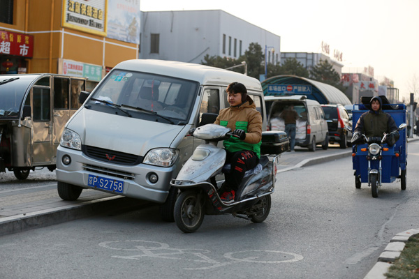 A minibus occupies a bicycle lane in violation of parking rules on Beitucheng East Road in northern Beijing on Tuesday. Feng Yongbin / China Daily 