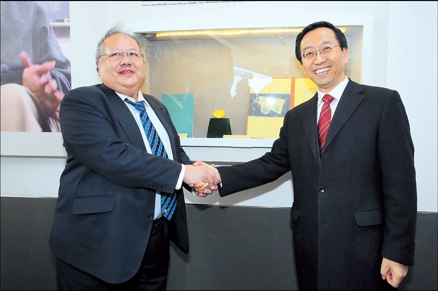 James Lee (left), son of Tsung-Dao Lee, shakes hands with Zhang Jie, president of Jiao Tong University, during the opening ceremony for the Tsung-Dao Lee Library at the university yesterday. 