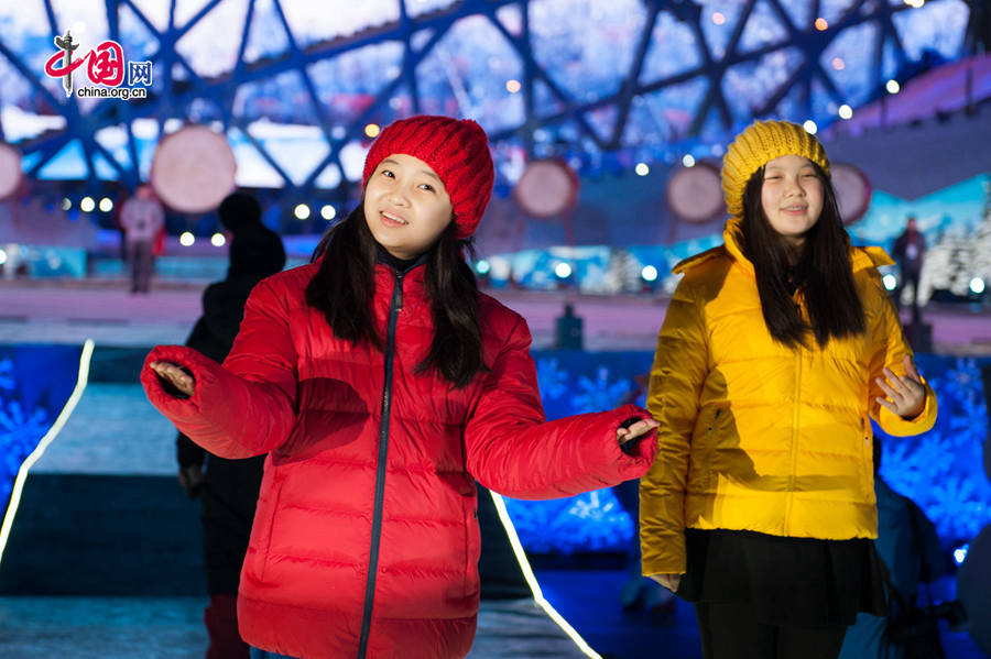 Lin Miaoke (Red) and her friends sing at the rehearsal of Countdown to 2015, the New Year celebration, on Dec. 30, one day ahead of the actual ceremony. The New Year celebration 'Countdown to 2015' holds its last rehearsal at Beijing's Olympic Park, where the national symbols of the Bird's Nest stadium and the Water Cube National Aquatics Center are located, on Tuesday, Dec. 30, 2014. The ceremony also features the Chinese capital's bidding for the 2022 Winter Olympics. [Photo by Chen Boyuan / China.org.cn]