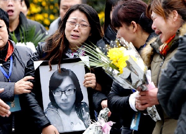 Relatives mourn at the site of the New Year's Eve stampede on the Bund yesterday, the seventh day of the tragedy that left 36 people dead, mostly in their early 20s, and another 49 injured. According to traditional beliefs, souls of the deceased revisit families on the seventh day. — Xinhua 