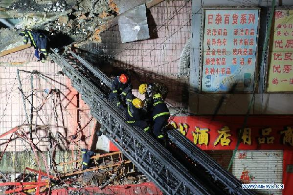 Rescuers save a buried firefighter on the scene of a warehouse fire at Beifangnanxun ceramics market in Harbin, capital of northeast China's Heilongjiang Province, late on Jan. 2, 2015. Five firefighters were dead and another 14 were injured, including a security, according to local authorities. [Photo/Xinhua]