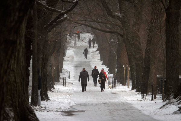 People walk up 5th Avenue at Central Park as it snows in the Manhattan borough of New York January 26, 2015. Winter Storm Juno has brought blizzard warning for New York and much of the North East United States. 