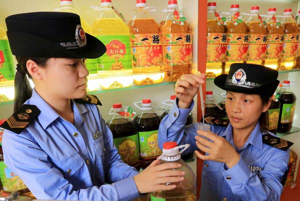 Law enforcers test edible oil at a store in a wholesale market in Liuzhou, the Guangxi Zhuang autonomous region, this month. Tan Kaixing / for China Daily