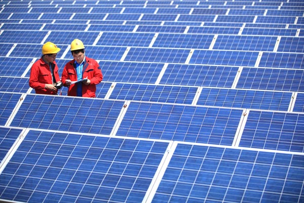 Technicians check solar panels at a textile company in Jimo, Shandong province. [Photo/China daily]