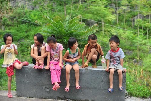 Qin Xiaohui (R) plays with the other children in his village on July 5, 2012. Qin Xiaohui, then 6, lives in Banlie Village of Bansheng Township in Dahua Yao Autonomous County, South China's Guangxi Zhuang autonomous region. [Photo/Xinhua]