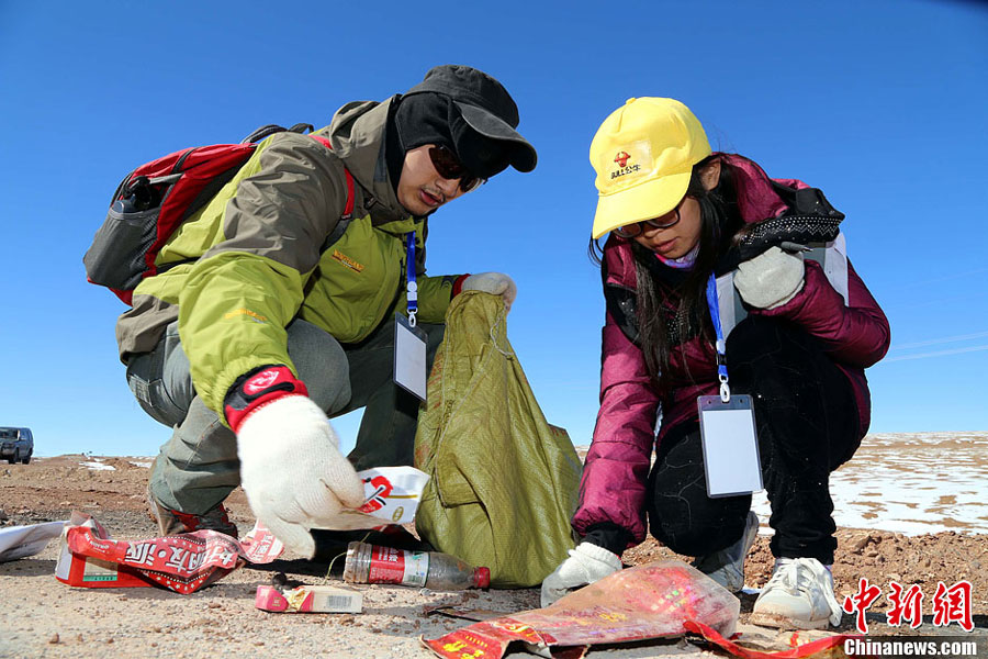 A pair of volunteers participate in a program called 'Pack Out a Bag of Trash' on Oct. 17, 2013. [File Photo: Chinanews.cn]
