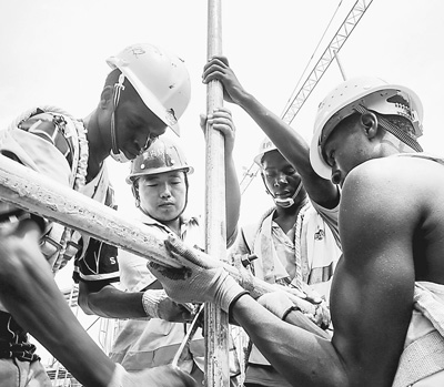 Chinese engineer Zhang Qingchun and Kenyan workers work at the Mombasa West Station. [People's Daily]