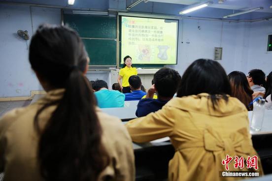 A female teacher talks with her students at a sex education class in a Chinese university. [China News Service] 