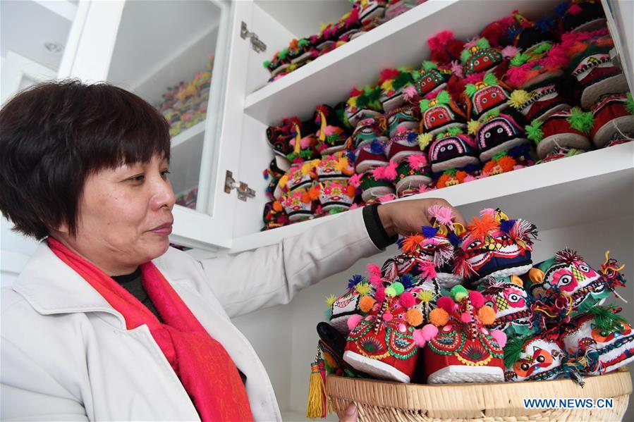 Collector Hu Shuqing displays her collection of tiger-head shoes in Zhengzhou City of central China's Henan Province, March 10, 2017. Hu collected more than 10,000 tiger-head shoes. This type of shoes is traditional Chinese folk handicraft used as footwear for children with the hope that children will become as robust and dynamic as tigers. [Photo/Xinhua]