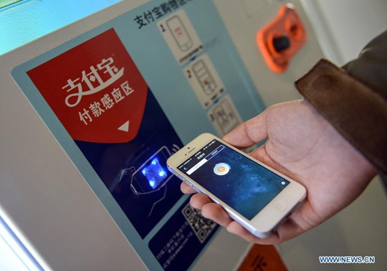 A staff member demonstrates mobile-payment process at Alipay's headquarters in Hangzhou, capital of east China's Zhejiang Province, Jan. 10, 2014. [Photo/Xinhua]