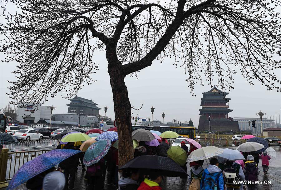 People walk in rain nearby the Tian'anmen Square in Beijing, capital of China, March 23, 2017. A cold front brought rainfall to Beijing on Thursday, and a snowfall is expected to hit the city on Friday. (Xinhua/Luo Xiaoguang) 