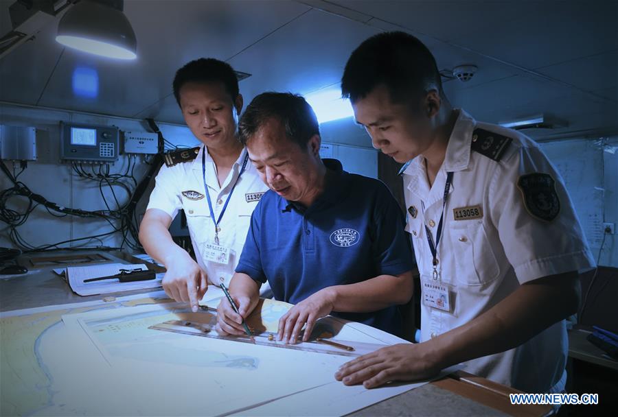 Workers of Sanya Maritime Safety Administration and captain of 'Xiangyanghong 09', carrier of China's manned deep-sea submersible Jiaolong, check the anchorage on a map in Sanya, south China's Hainan Province, April 8, 2017. The crew of China's 38th ocean scientific expedition returned to Sanya, Hainan Province, south China, Wednesday. The 59-day trip marks the conclusion of the first stage of a 124-day mission. [Photo/Xinhua] 