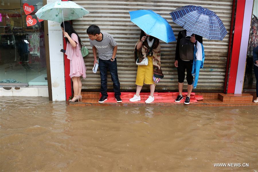 People stand by a flooded street in Weining County, southwest China's Guizhou Province, June 11, 2017. Heavy rain hit Guizhou since Sunday.(Xinhua/He Huan) 