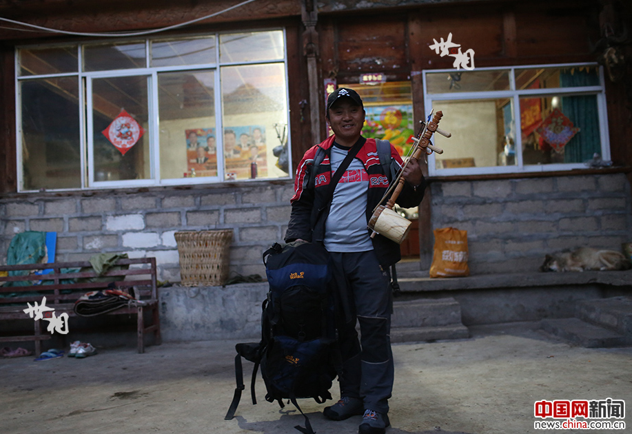 Aqingbu is packed and ready to set out for a long journey to clear garbage. His luggage includes a backpack, a sleeping bag and a 'Xuanzi' – a three-stringed musical instrument. [Photo by Bai Jikai/China.com.cn]