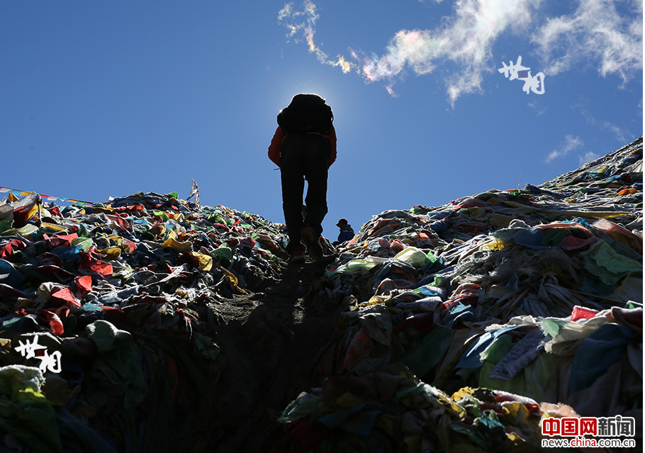 Kangjin Wangxue, 17, climbs over Duokelaya Pass in the morning. It is his first time participating in the garbage-cleaning activity. [Photo by Bai Jikai/China.com.cn]