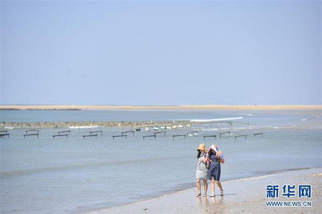 福建省晋江市金井镇塘东村的海上沙堤在碧海蓝天中美若玉带，国庆期间吸引不少游客前来欣赏这一独特的风景。