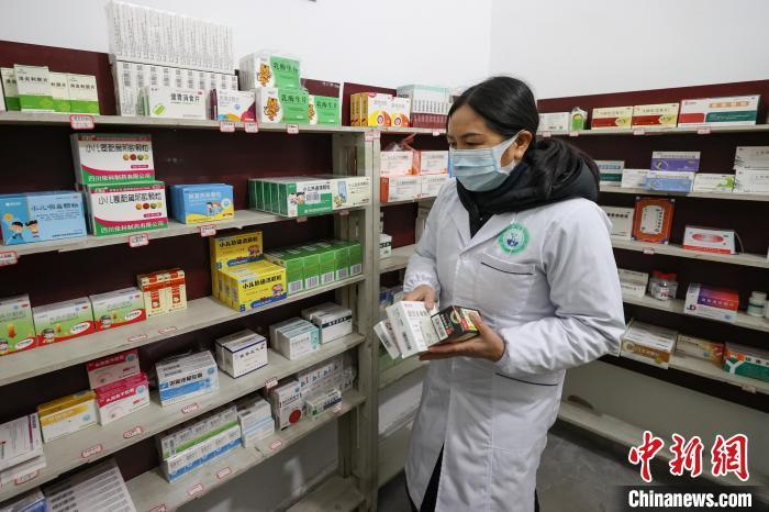 1月3日,贵州贵定云雾镇摆谷村卫生室,村医罗海香在药房内出诊前配药。 瞿宏伦 摄