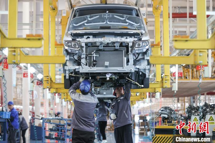 3月13日，工人在安裝汽車發動機。　瞿宏倫 攝